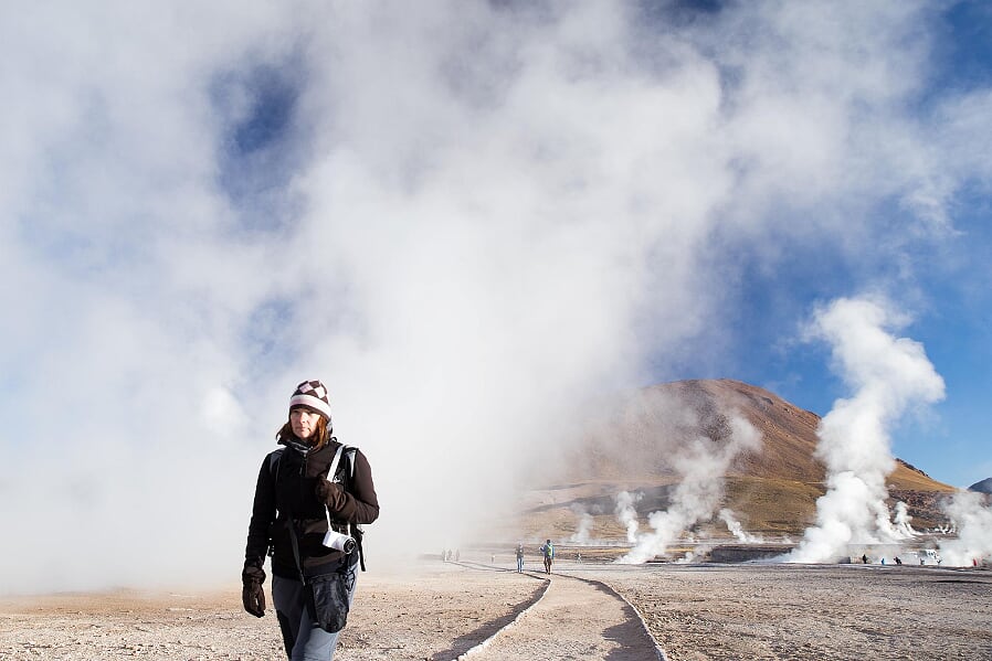 Touristin vor den dampfenden Geysiren del Tatio, Atacama-Wüste, Chile